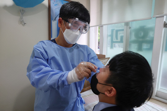 2일 오후 서울 시내의 한 병원에서 의사가 신속항원검사를 하고 있다. <연합뉴스>